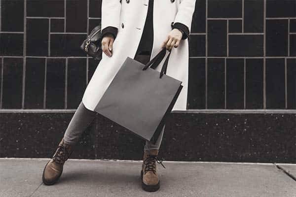 a woman standing holding a bag