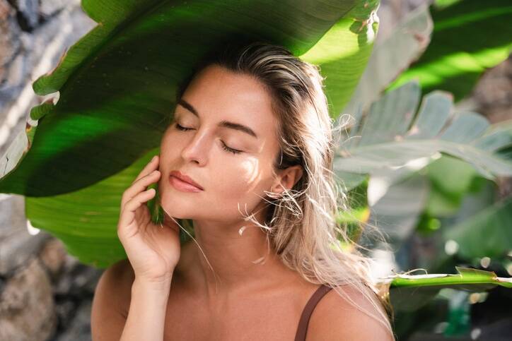 Summer facials- A beautiful women with a leaf behind her