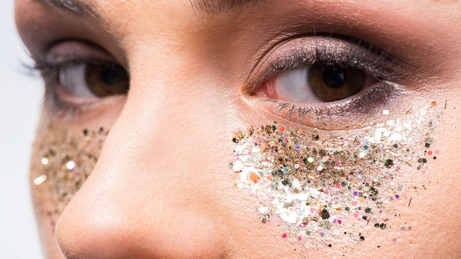 attractive woman with glitter under eyes looking at camera