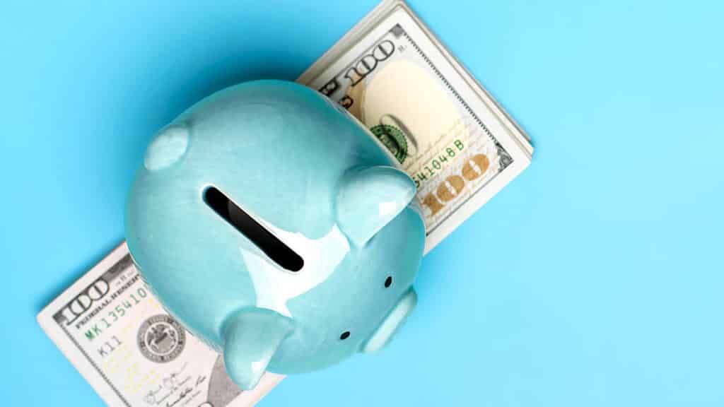 piggy bank, dollars banknote on blue background Buying, sale, investment, banking, loan, insurance concept Flat lay Top view Business and finance.