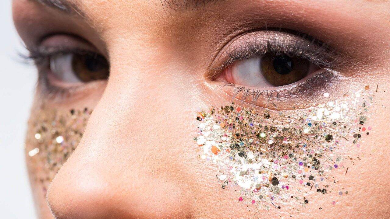 attractive woman with glitter under eyes looking at camera